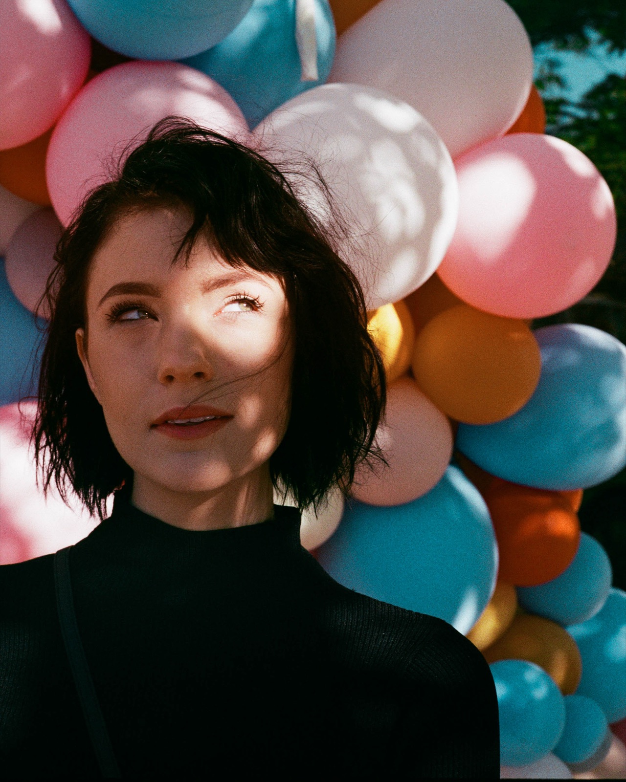 Editorial senior portrait in front of a balloon backdrop
