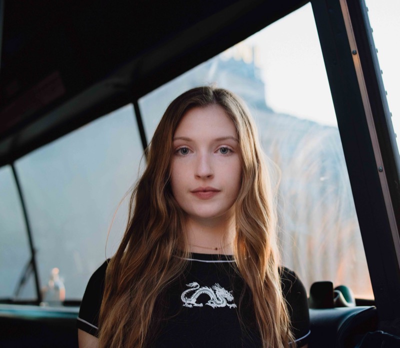 Moody senior portrait by a city window